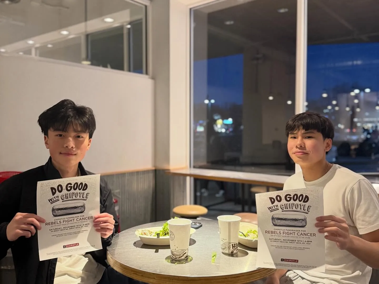 Two students holding fundraiser flyers at Chipotle