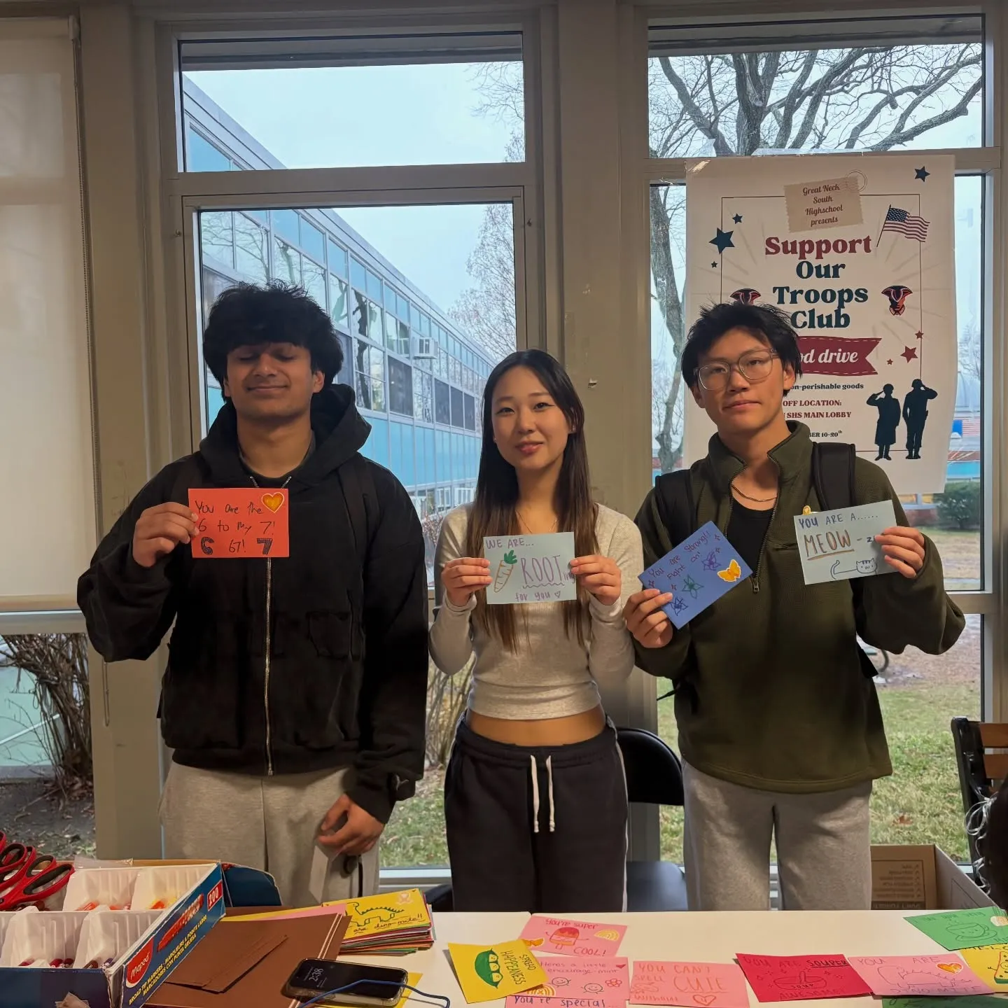 Three students showing their finished cards