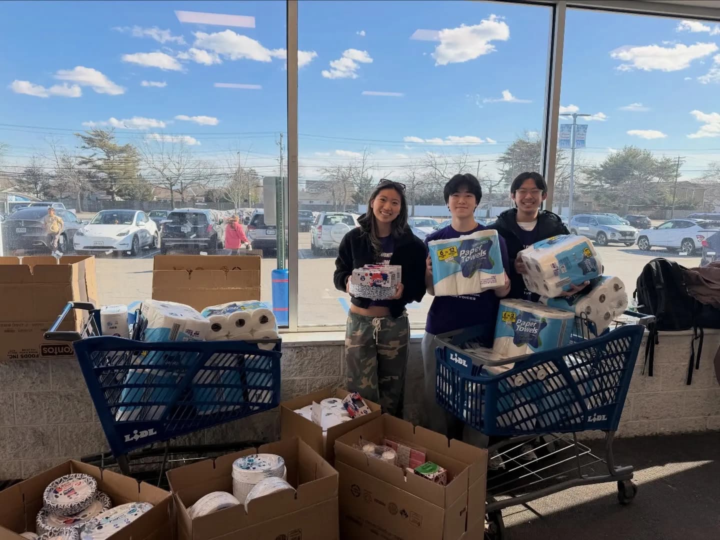 Volunteers with carts full of donated kitchen supplies